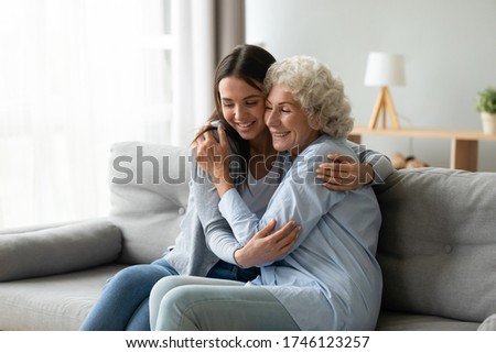 Happy multi-generational family sitting on couch in living room, elderly grandmother snuggle to grown up granddaughter, adult daughter missed mature mom, holidays, events, Mother Day congrats concept Stock photo © 