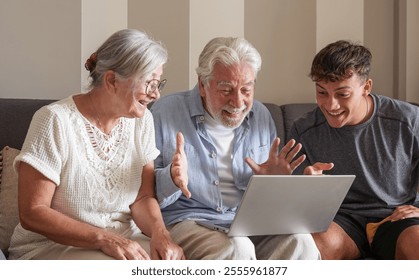 Happy multigenerational family of white-haired grandparents and young grandson in video call by laptop sitting together at home. Three generations of caucasian family - Powered by Shutterstock