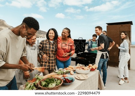Happy multigenerational people having fun doing barbecue grill at house rooftop - Summer gatherings and food concept