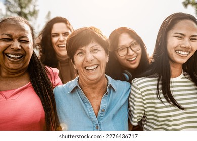 Happy multigenerational women with different ethnicity having fun smiling in front of camera in a public park - Females empowerment concept - Powered by Shutterstock