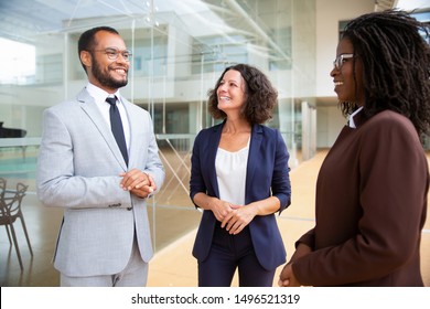 Happy multiracial business colleagues. Smiling multiethnic male and female business people standing together and talking. Cooperation concept - Shutterstock ID 1496521319