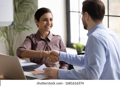 Happy multiracial businesspeople shake hands at meeting greeting getting acquainted, smiling diverse business partners handshake close deal make agreement after successful negotiation or briefing