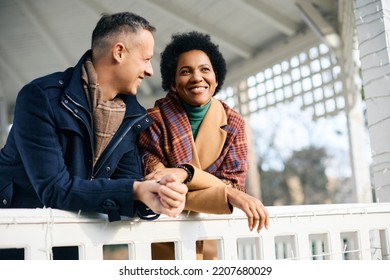 Happy multiracial couple spending winter day at the park. Focus is on African American woman.  - Powered by Shutterstock