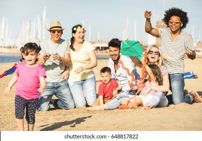 Happy Multiracial Families And Children Playing Together With Kite At Beach Vacation - Multicultural Summer Joy Concept With Mixed Race People Having Candid Genuine Fun  - Warm Afternoon Color Tones