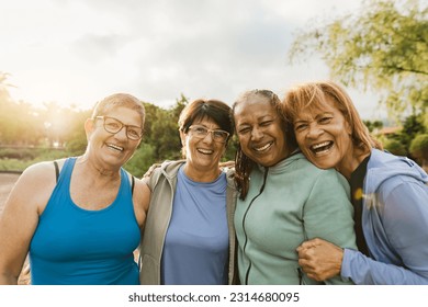 Happy multiracial female friends having fun smiling in front of the camera after training session at park - Powered by Shutterstock