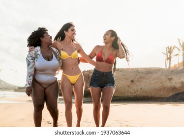 Happy multiracial females with different body size having fun on the beach during summer holidays - Powered by Shutterstock