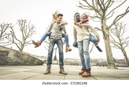 Happy Multiracial Friends Couples Having Fun With Piggiback In Winter Time Waiting Spring - Friendship Concept With Multicultural Young People With Funny Attitude - Retro Desaturated Contrast Filter