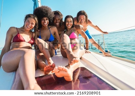 Happy multiracial friends doing sea tour with sailing boat - Summer and vacation concept - Main focus on center guys faces