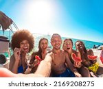 Happy multiracial friends eating watermelon while doing sea tour with sailing boat - Summer and vacation concept - Main focus on center man face