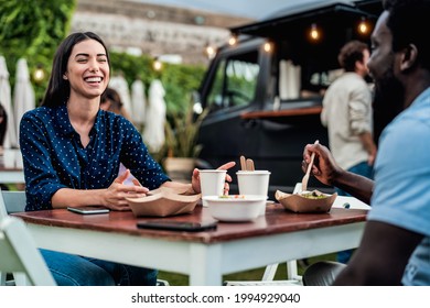 Happy multiracial friends having fun eating in a street food truck  - Powered by Shutterstock