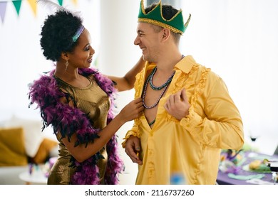 Happy Multiracial Friends Having Fun While Getting Dressed For Mardi Gras Carnival At Home.