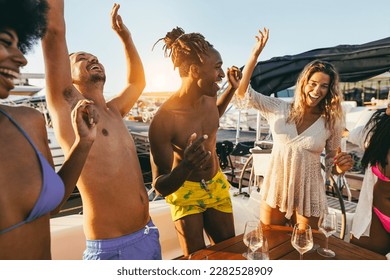 Happy multiracial friends having fun dancing together at boat party outdoor - Soft focus on african man head - Powered by Shutterstock