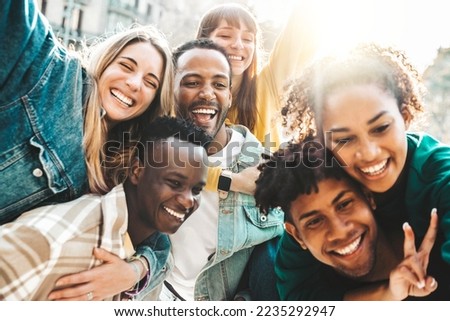 Happy multiracial friends having fun hanging out on city street - Group of young people laughing out loud together outside - Friendship concept with guys and girls enjoying weekend 