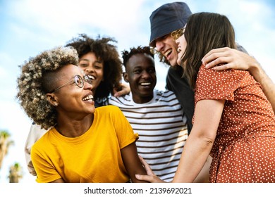 Happy multiracial friends laughing out loud together - Diverse young people having fun walking outdoors - Friendship concept with guys and girls socializing and joking outside - Shutterstock ID 2139692021