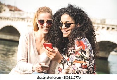 Happy multiracial girlfriends having fun outdoors with mobile smart phone - Friendship concept with girls at spring break travel - Modern female lifestyle with women best friends - Bright filter tone