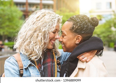 Happy multiracial girlfriends in love embracing and cuddling - Lesbian couple, millennials women, girls in London living happy lifestyle - LGBTQ concept with mixed race beautiful couple - Powered by Shutterstock