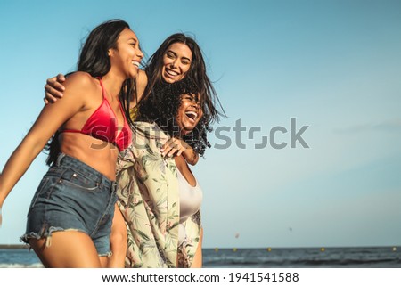 Happy multiracial girls with different body size having fun on the beach during summer holidays