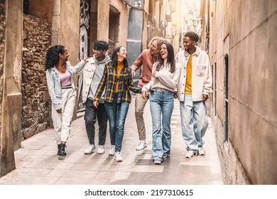 Happy multiracial group of friends walking on city street - Cheerful young people hanging outside together - Friendship concept with guys and girls having fun outdoors - Powered by Shutterstock