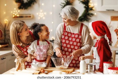 Happy multiracial kids help grandmother to cook Christmas cookies while standing together behind table in cozy kitchen at home, loving senior grandma baking with grandchildren during winter holidays - Powered by Shutterstock