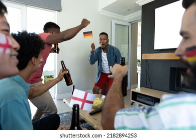 Happy Multiracial Male Friends With Beer Bottles And Flags Dancing And Celebrating Victory At Home. Winning, Sport, Alcohol, Unaltered, Togetherness, Social Gathering, Enjoyment, Weekend Activities.