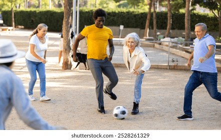 Happy multiracial men and women of various age at play of football game outdoors on a sunny day at park - Powered by Shutterstock