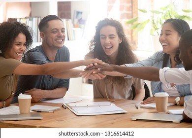 Happy multiracial office business people colleagues employees engaged in teambuilding stacking hands motivated by corporate success, team support unity power, help in teamwork collaboration concept