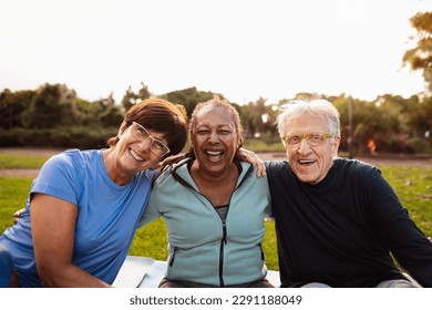 Happy multiracial senior friends having fun smiling at the camera after training activities in the park - Powered by Shutterstock