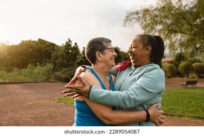 Happy multiracial senior women having fun after workout activities in a public park - Health elderly people concept - Powered by Shutterstock