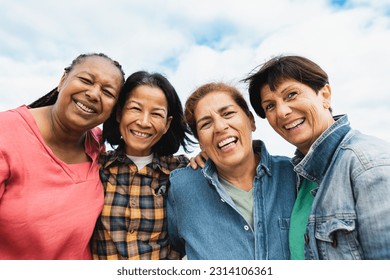 Happy multiracial senior women having fun smiling into the camera at house rooftop - Powered by Shutterstock