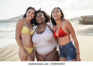 Happy multiracial women with different bodies and skins having fun in summer day on the beach - Main focus on center girl face - Powered by Shutterstock