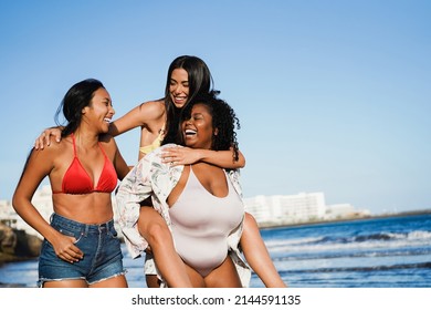 Happy multiracial women with different bodies and skins having fun in summer day on the beach - Focus on curvy girl face