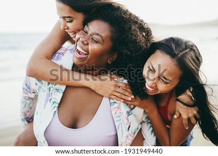 Happy multiracial women with different bodies and skins having fun in summer day on the beach - Main focus on right girl face
