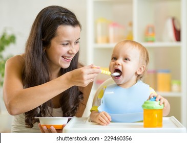 Happy Mum Spoon Feeding Child Son Indoor