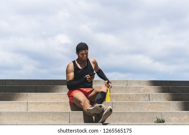 Happy Muscular Fit Sport Man Sprinter Resting After His Workout And Using Mobile Phone