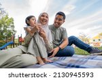 
Happy Muslim Family Have A Picnic Outdoor smiling to each other