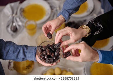 Happy Muslim family having iftar dinner to break fasting during Ramadan dining table at home or restaurant.	 - Shutterstock ID 2268758215