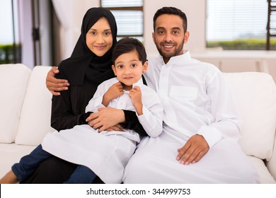 happy muslim family sitting on the couch at home