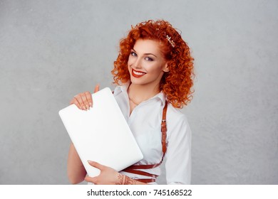 Happy with my laptop. Closeup portrait head shot professional beautiful confident young businesswoman holding computer isolated gray studio wall background Multicultural mixed race asian russian model