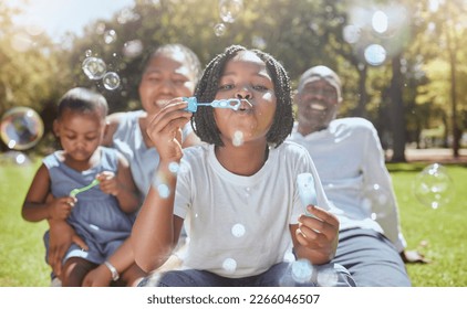 Happy, nature and black family blowing bubbles while playing, bonding and enjoying summer in the park. Happiness, father and mother with children having fun together in a green garden in South Africa - Shutterstock ID 2266046507
