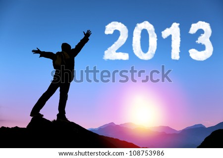 happy new year 2013. young man standing on the top of mountain watching the sunrise and cloud 2013