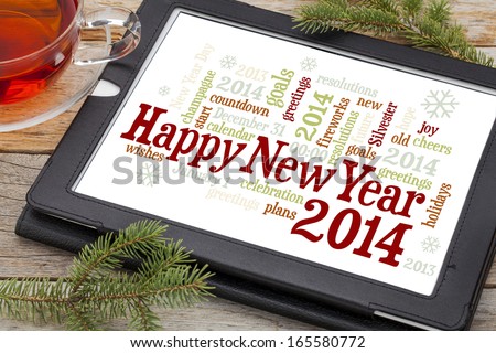 Happy New Year 2014 - word cloud on a digital tablet with a cup of tea and spruce twigs