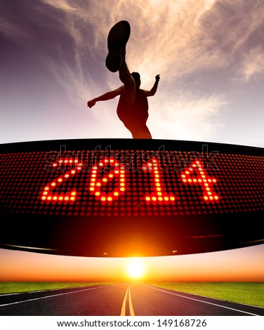 happy new year 2014.runner jumping and crossing over matrix display for celebrating 2014