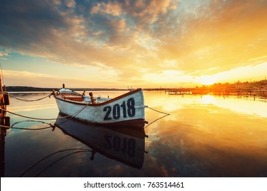 Happy New Year 2018 Concept, Lettering On The Boat With A Reflection In The Water At Sunset