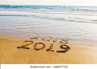 Happy New Year 2019 text on the sea beach. Abstract background photo of coming New Year 2019 and leaving year of 2018