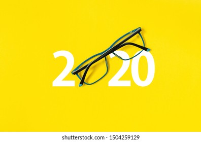 Happy New Year 2020. 2020 With Glasses On Yellow Isolated Background