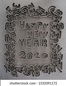 Happy New Year 2020 Written Out With Metal Cookie Cutter Letters Framed By The Remaining Alphabet And Numbers