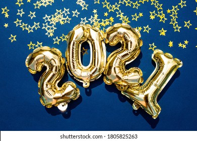 Happy New Year 2021 Celebration. Gold And Silver Foil Balloons Numeral 2021 And  Gold Confetti On On A Trendy Blue Background. Flat Lay.