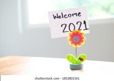 Happy New Year 2021 Concept.Sunflower And Ladybug Clip Card Holder With Welcome 2021 Written On White Paper.