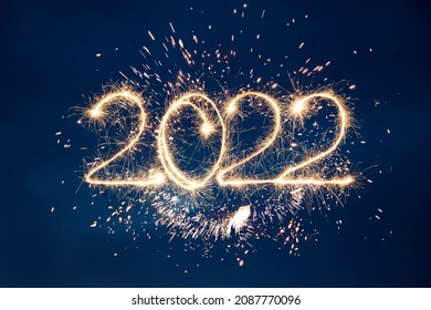 Happy New Year 2022. Beautiful creative holiday background with fireworks and Sparkling font 2022