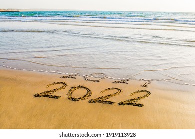 Happy New Year 2022 text on the sea beach. Abstract background photo of coming New Year 2022 and leaving year of 2021